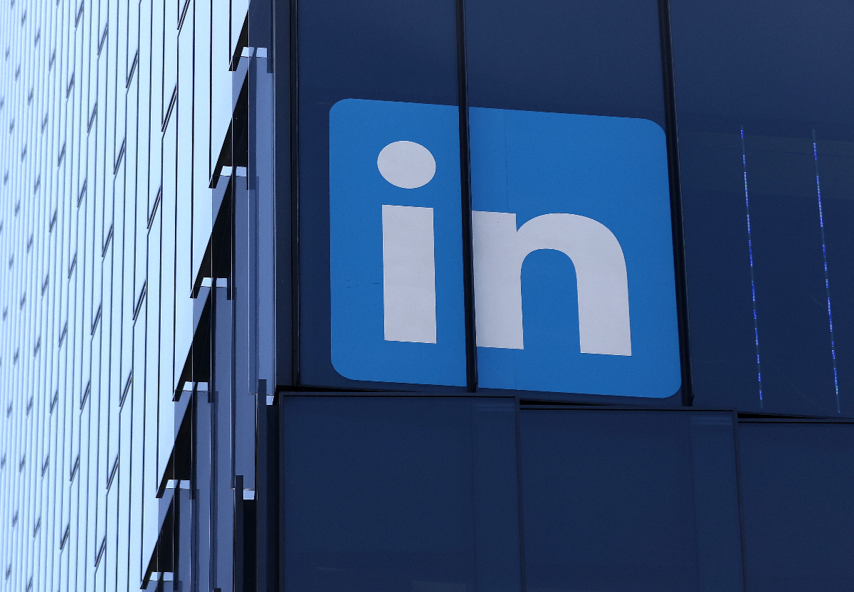 Blue LinkedIn logo displayed on a glass office building facade.