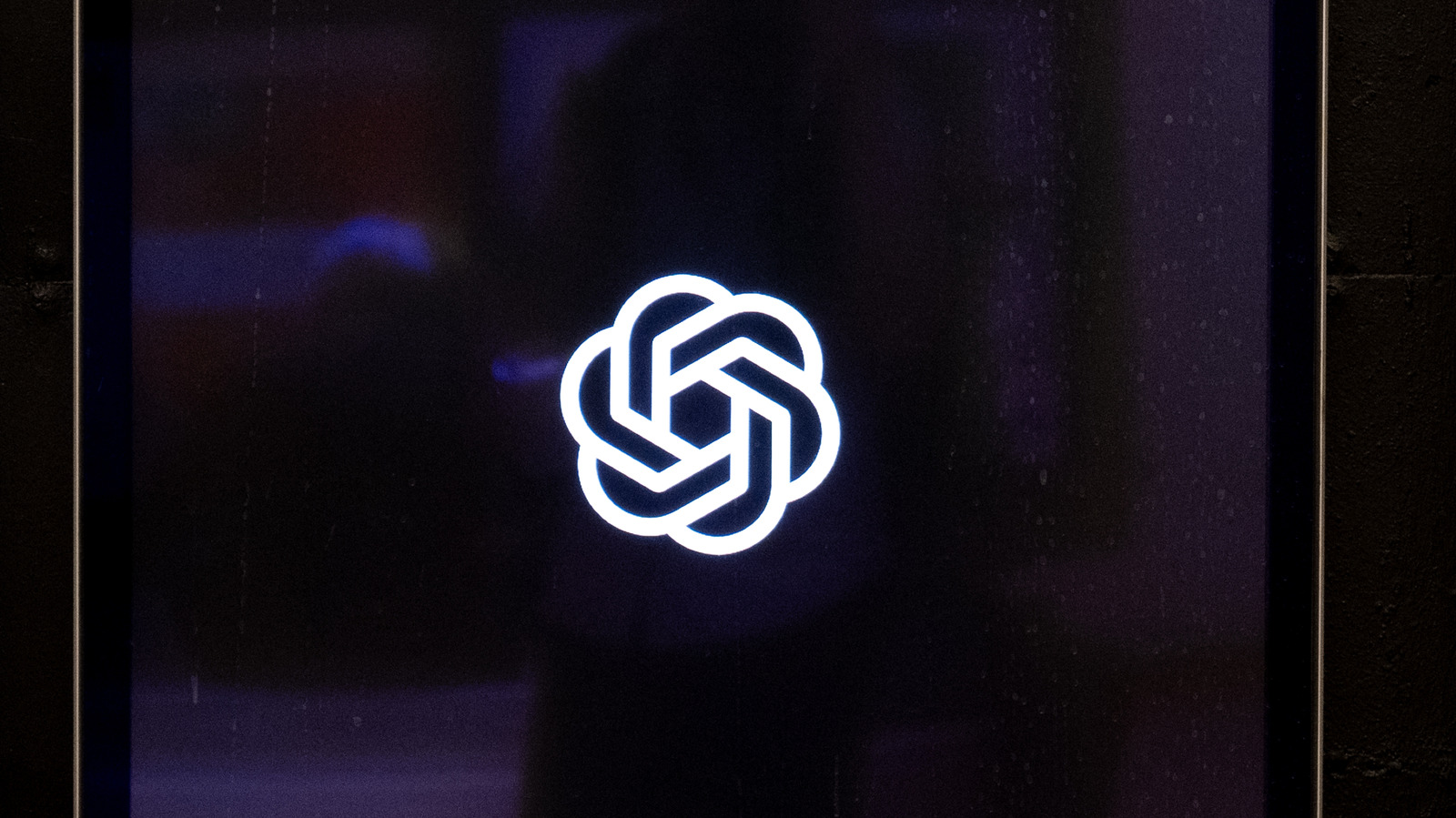 White interlocking knot emblem centered on a dark purple, softly glowing digital background.