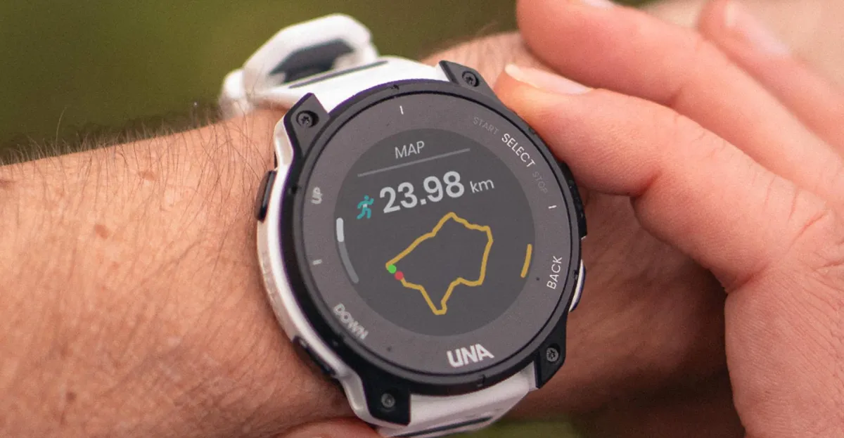 A white and black round sports watch on a wrist displays a route map and 23.98 kilometers.