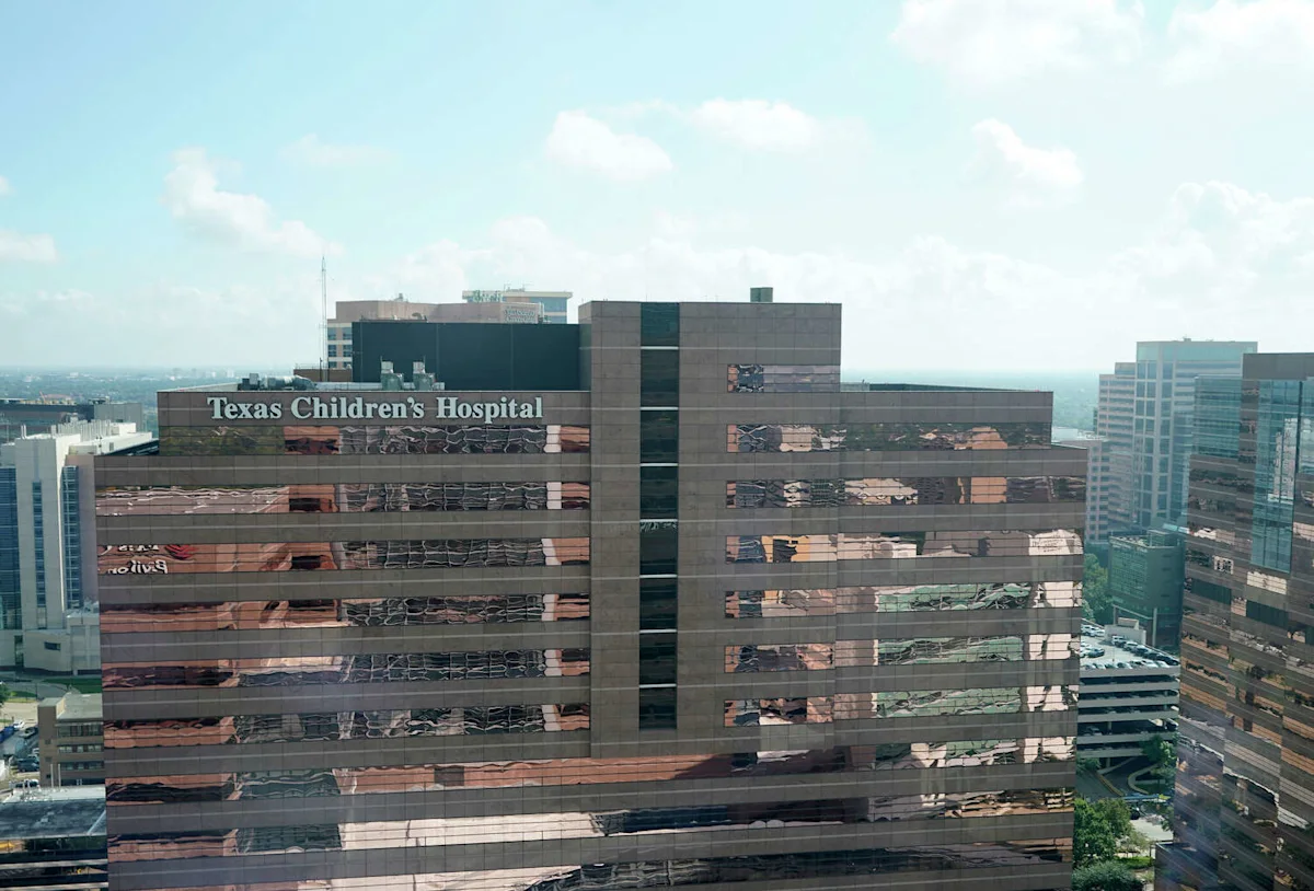 Aerial view of Texas Children’s Hospital buildings under a partly cloudy sky.