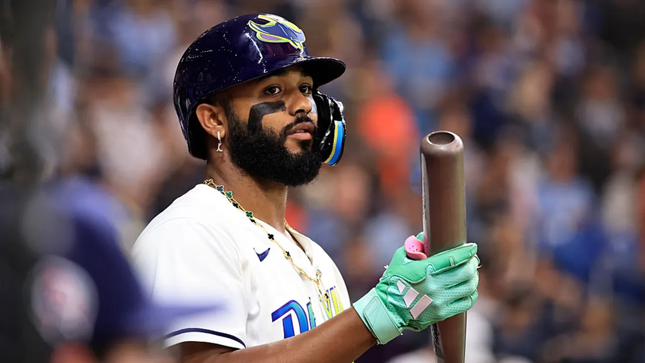 Bearded baseball player in helmet and gloves holding a bat during a game