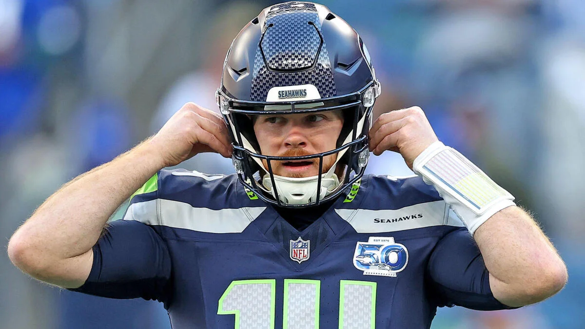 Seattle Seahawks football player adjusting his helmet and mouthguard during a game