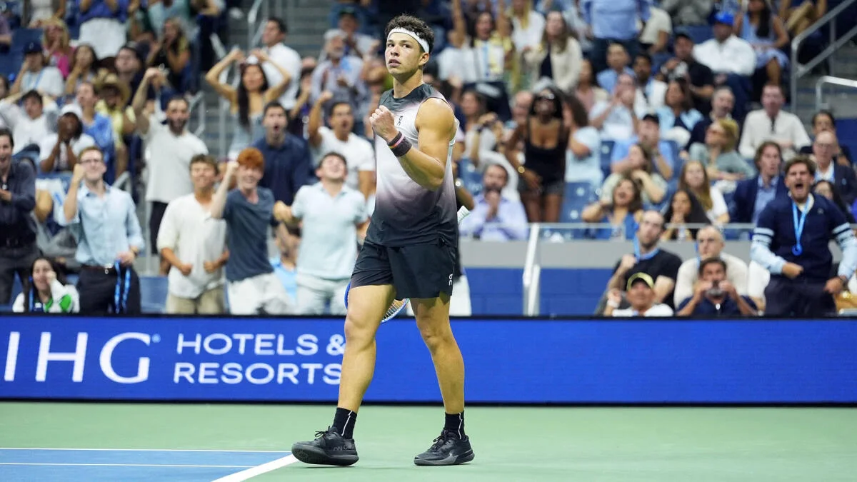 Tennis player celebrates on court as spectators cheer in the stands