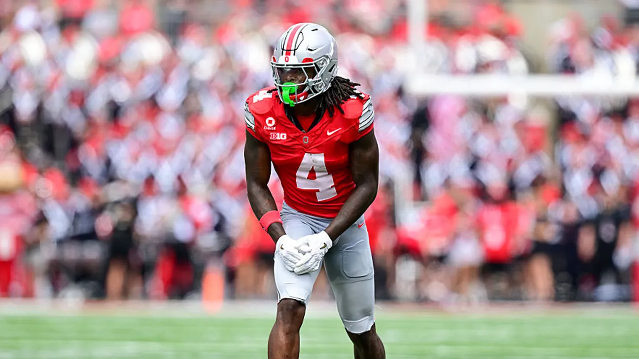 Ohio State football player wearing number 4 uniform and helmet on the field