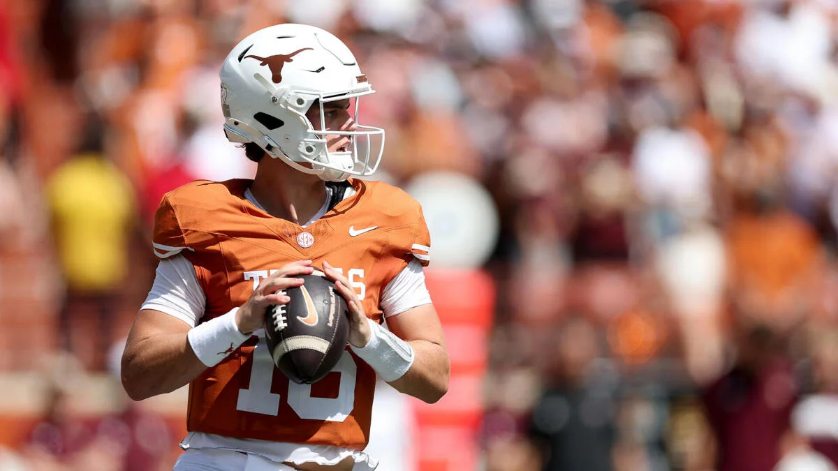 Quarterback in burnt orange uniform and white helmet holds a football during a game