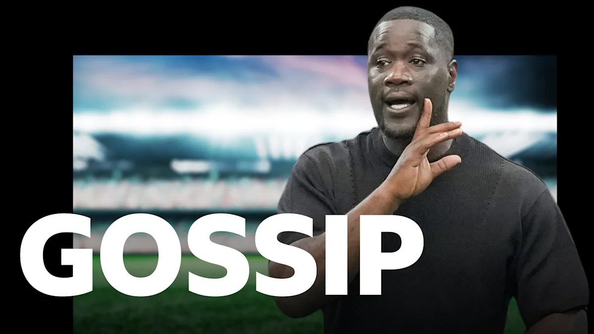 Man gesturing in front of a blurred football stadium with large white “GOSSIP” text
