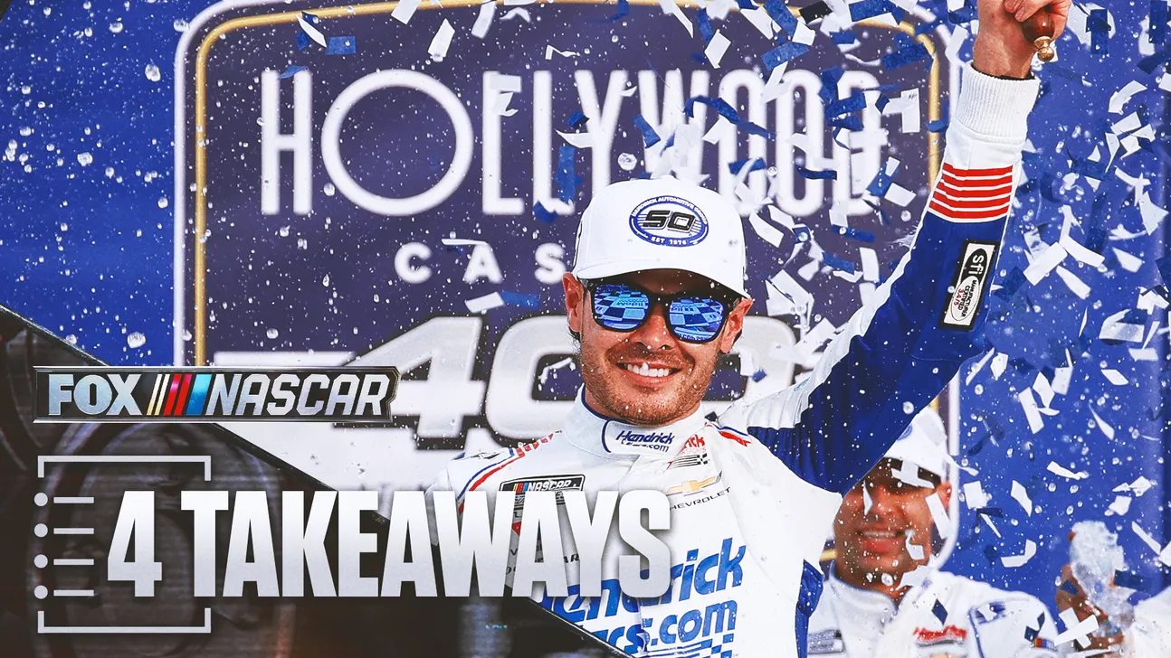Smiling driver in a white racing suit raises his arm amid falling confetti, with NASCAR graphics behind him.