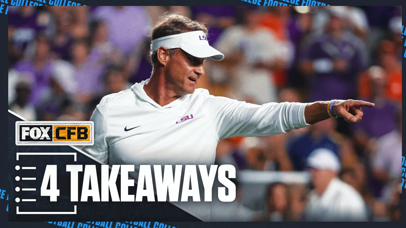 LSU coach in white visor points across the field during a football game