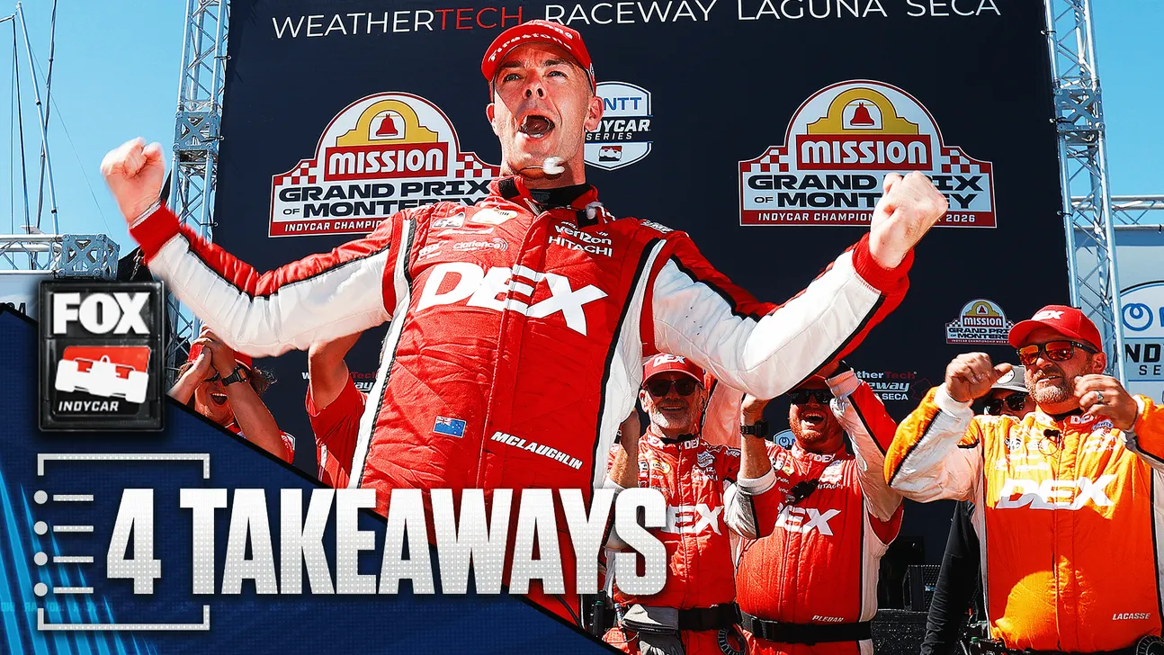 Race driver celebrates on podium with raised fists as teammates cheer behind him.