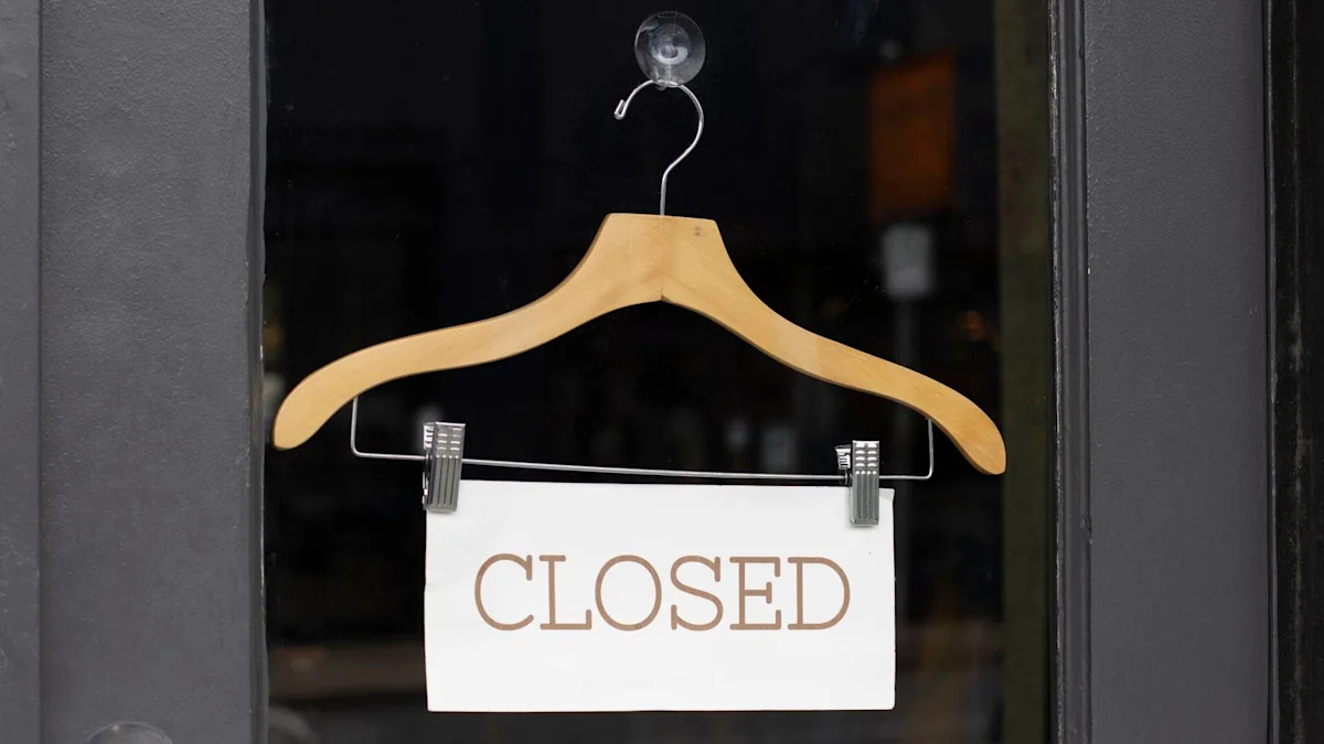 Closed sign hanging on a wooden coat hanger in a storefront window