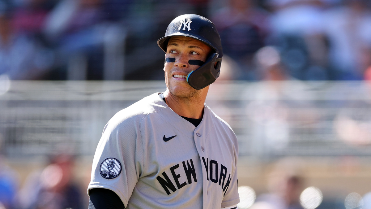 Baseball player in Yankees uniform and helmet looks toward the field during a game
