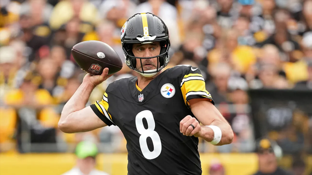 A Pittsburgh Steelers player in a black number 8 jersey prepares to throw a football.