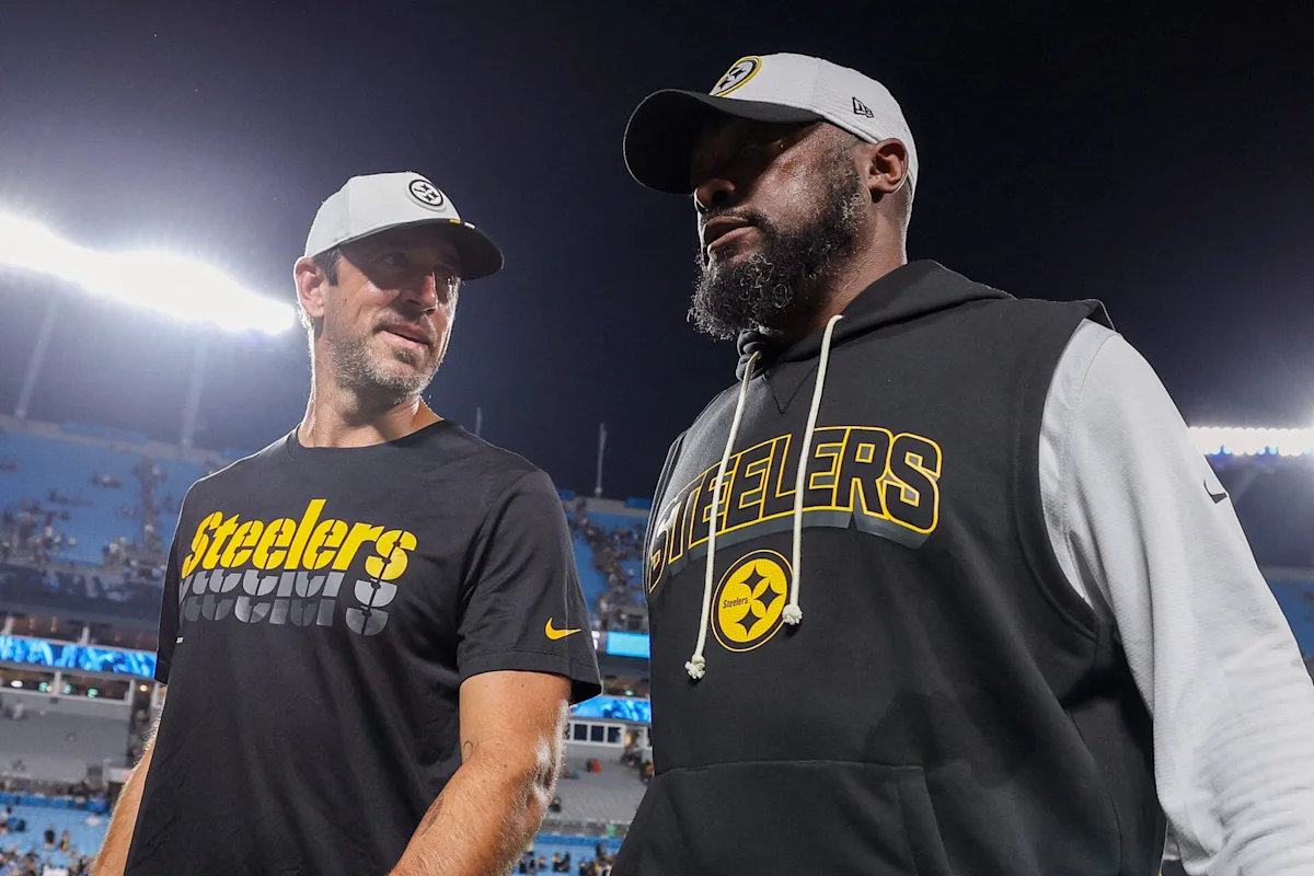 Two Pittsburgh Steelers figures in team apparel stand on a football field under stadium lights.