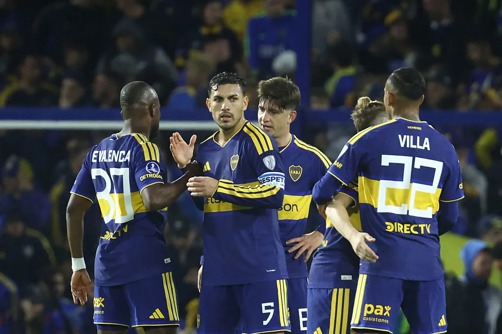 Boca Juniors players gather on the pitch during a match, wearing blue and yellow kits.