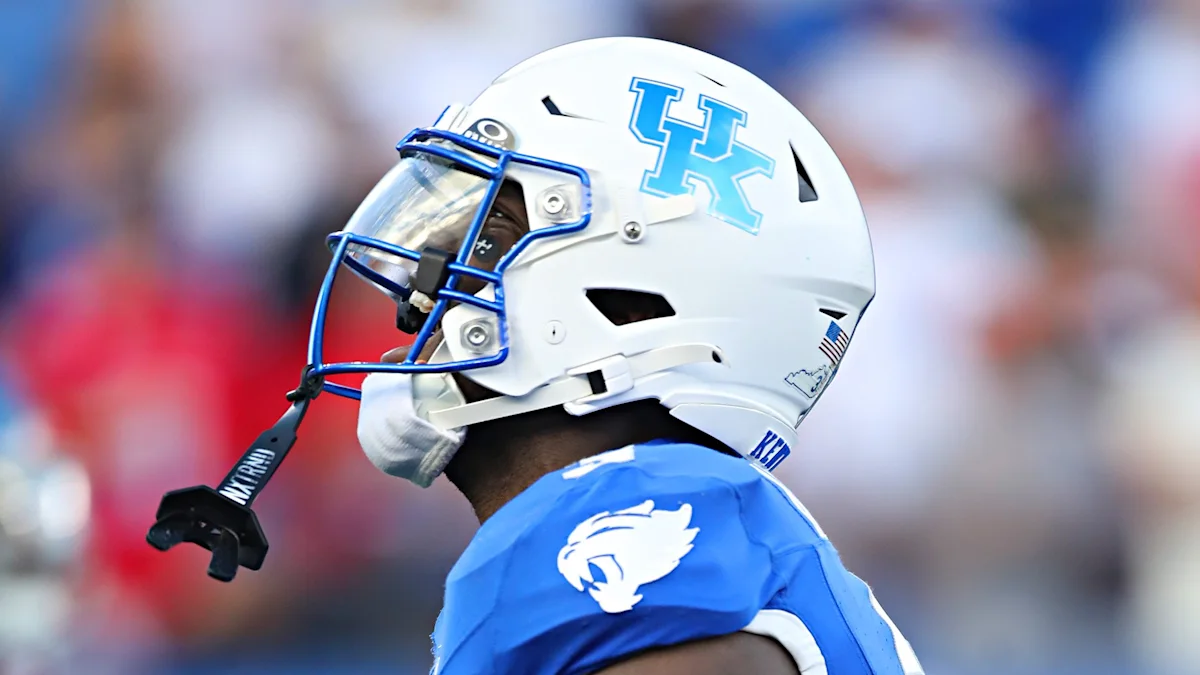 Close-up of a football player in a blue jersey and white helmet with a blue face mask.
