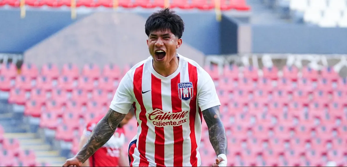 Soccer player in red-and-white striped jersey celebrates with mouth open in stadium