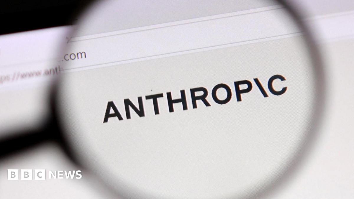 A magnifying glass enlarges the ANTHROPIC name displayed on a computer screen.