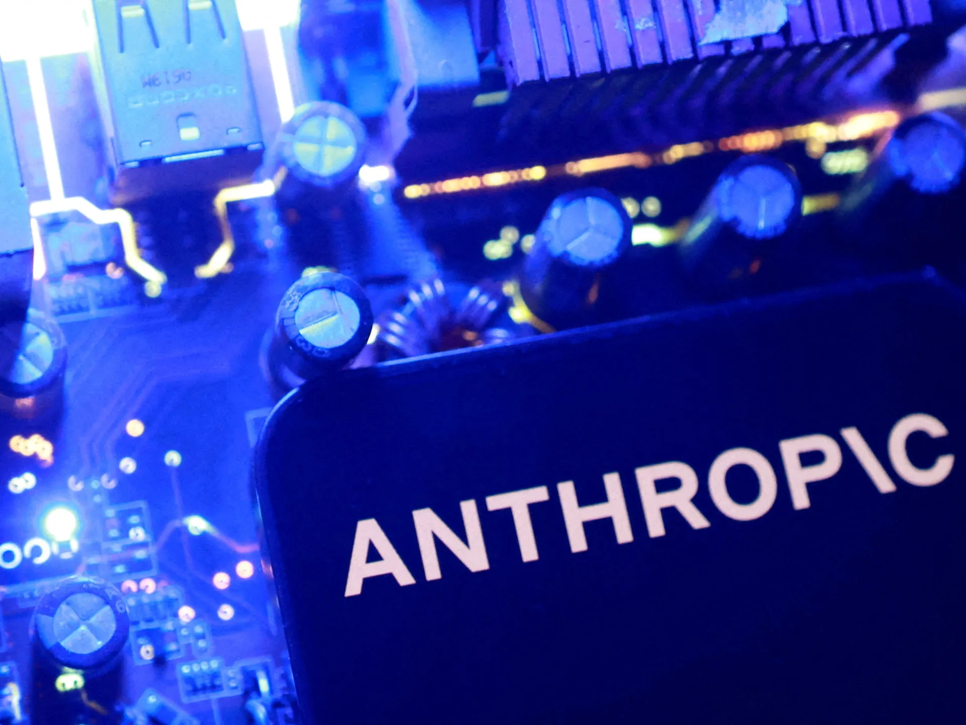 Close-up of an audio mixing console with Anthropic branding in blue lighting