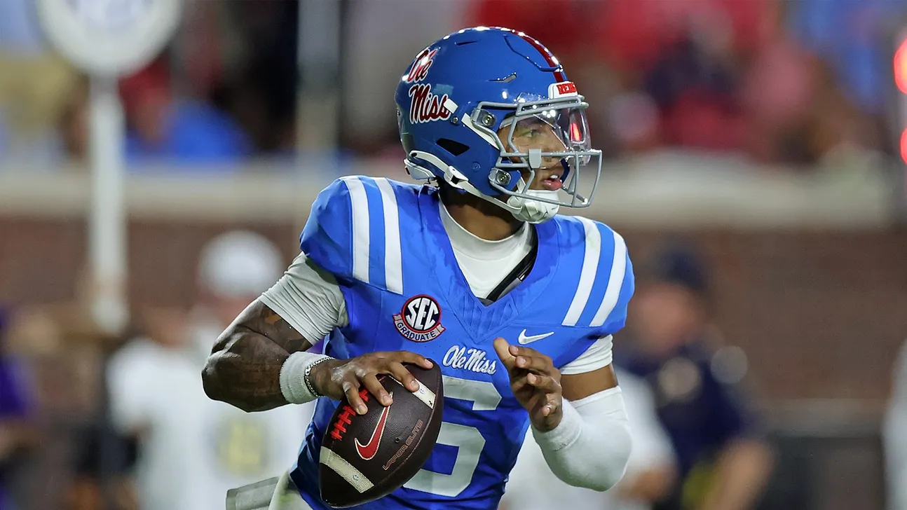 Ole Miss football player in blue uniform runs with the ball during a game