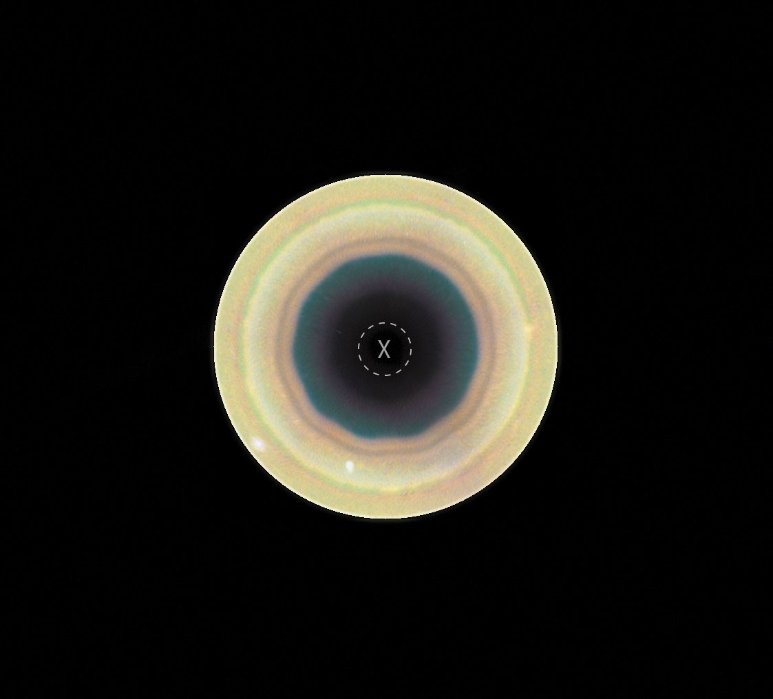 Circular multicolored ring pattern surrounding a dark center on a black background