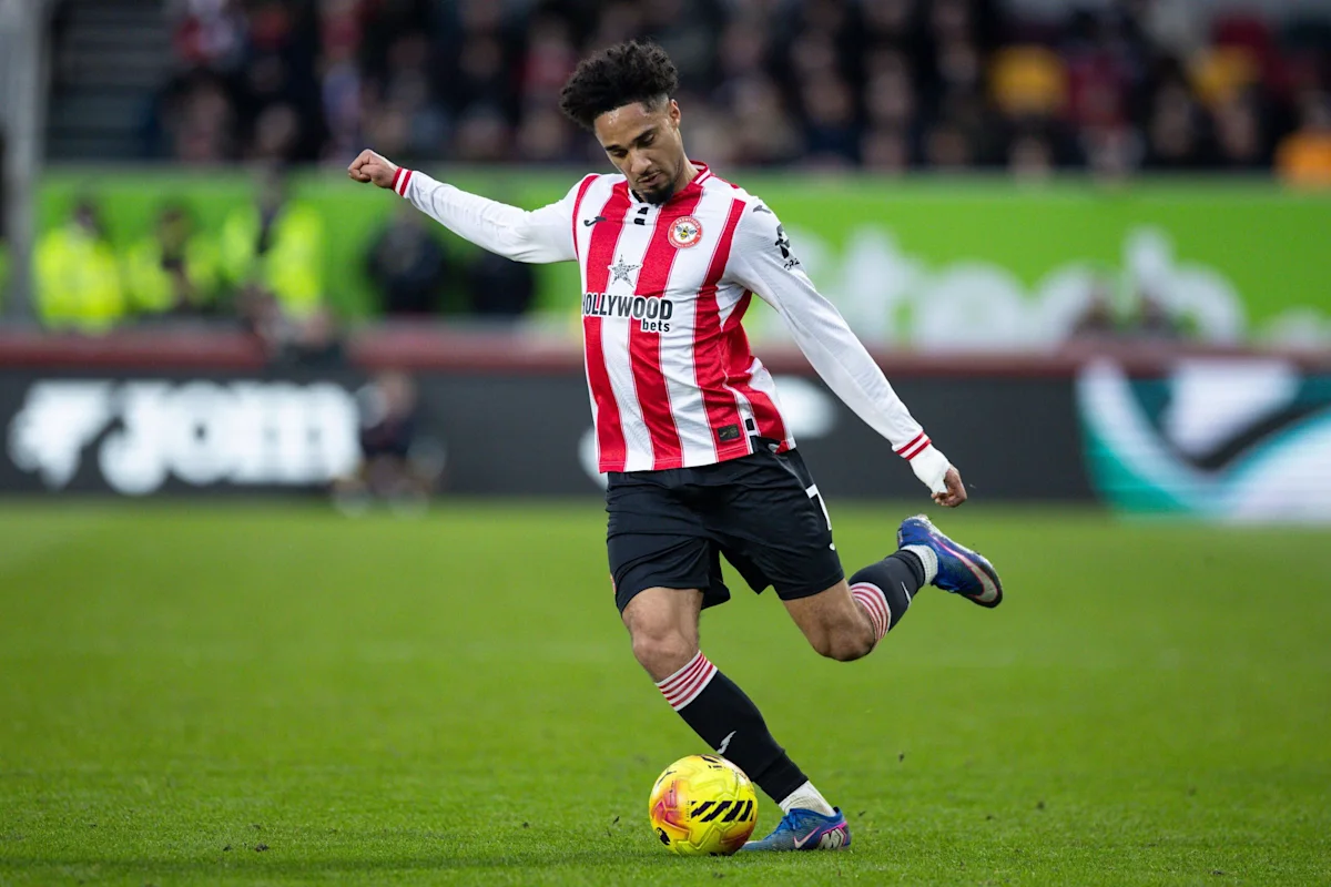 Brentford footballer strikes a yellow ball during a Premier League match