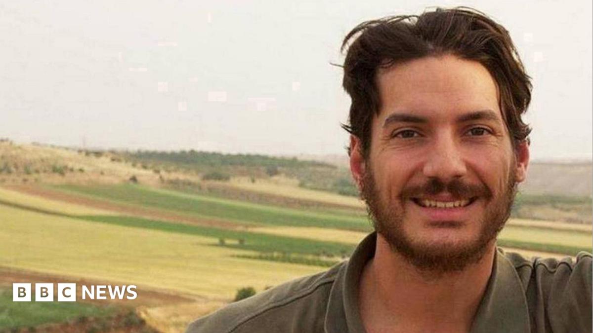 Bearded man smiling in a field, with a BBC News logo at lower left