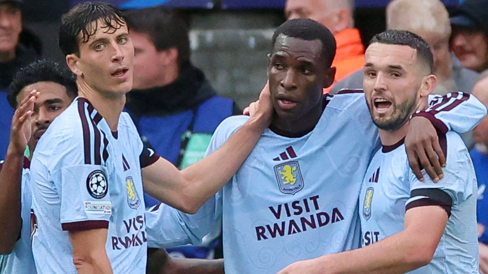 Aston Villa players in light blue kits celebrate together during a football match
