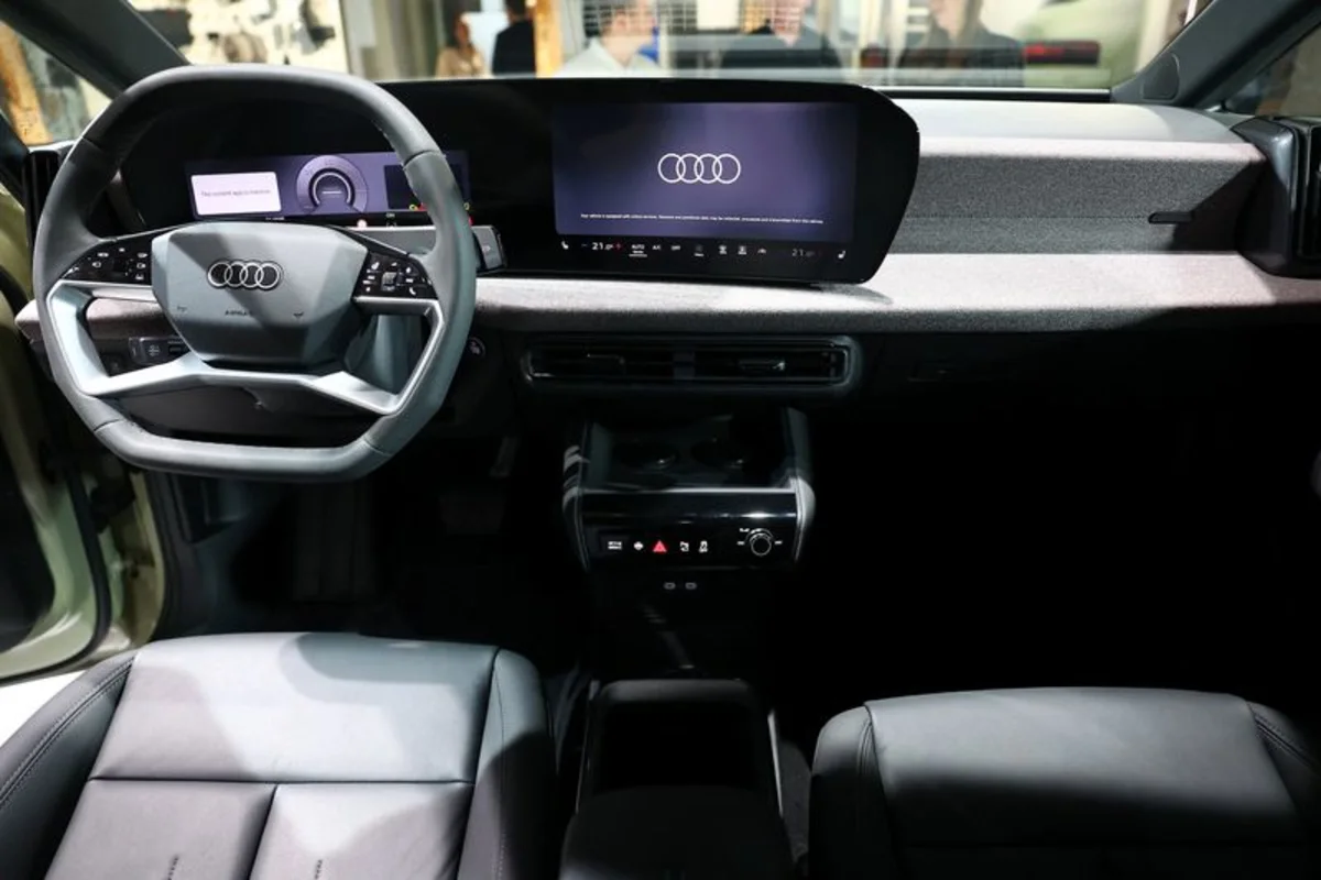 Audi vehicle interior with steering wheel, digital displays, dashboard, center console, and front seats