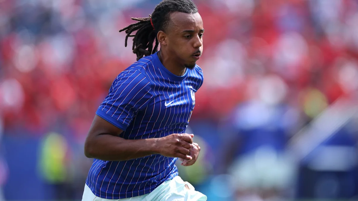 A footballer in a blue pinstriped jersey runs across the pitch during a match.