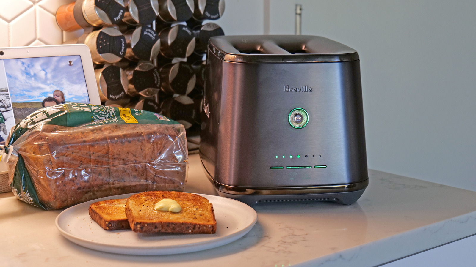 Breville toaster beside a loaf of bread and two slices of toast on a plate.