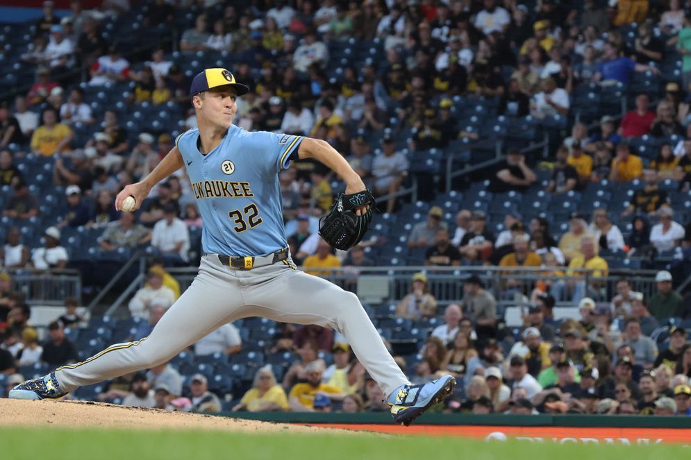 Milwaukee Brewers pitcher in blue uniform delivers a pitch during a baseball game