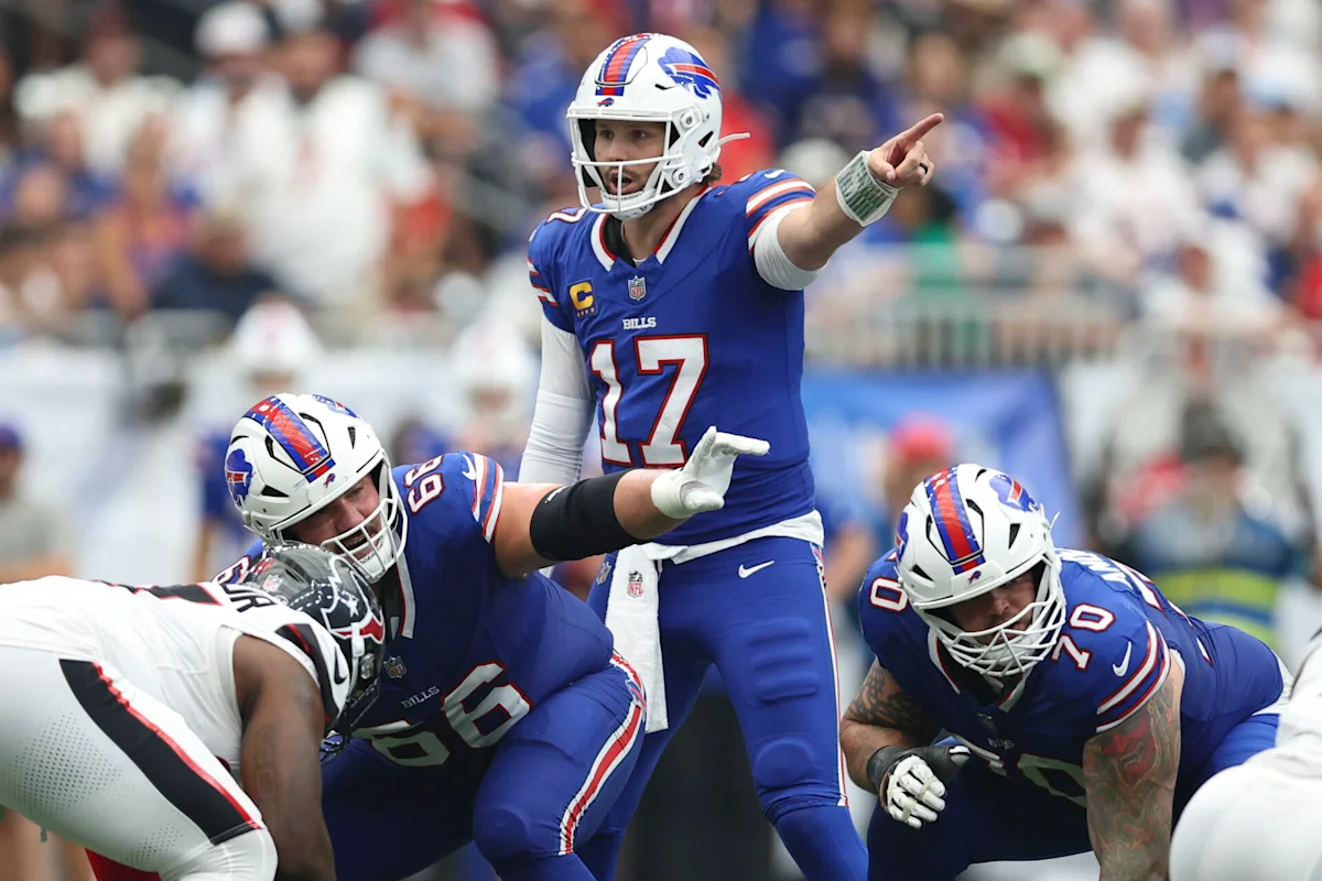 Buffalo Bills quarterback points downfield as teammates line up during an NFL game