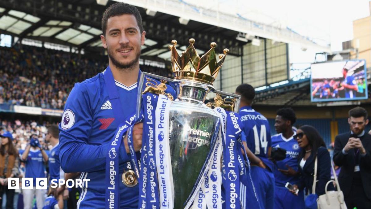 Chelsea footballer holds the Premier League trophy during a stadium celebration.