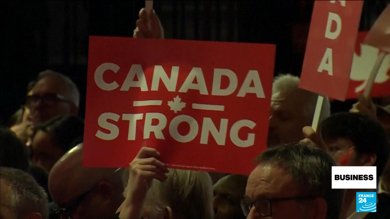 Crowd member holds a red “Canada Strong” sign above a gathering.