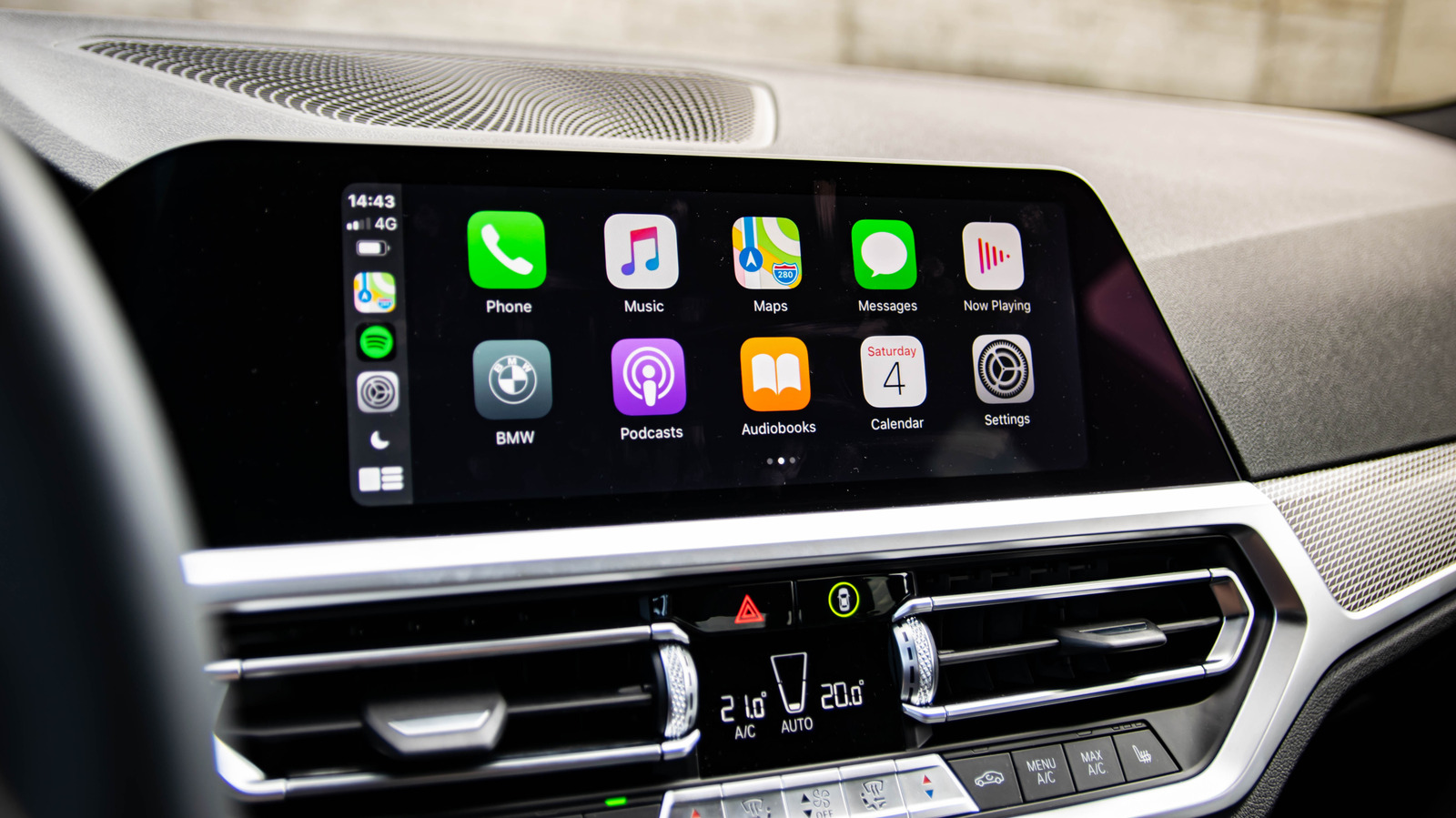 BMW dashboard display showing Apple CarPlay app icons and climate controls