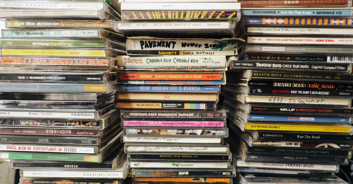 Stacks of compact discs, including albums by Radiohead, Blur and Pavement, fill the frame.