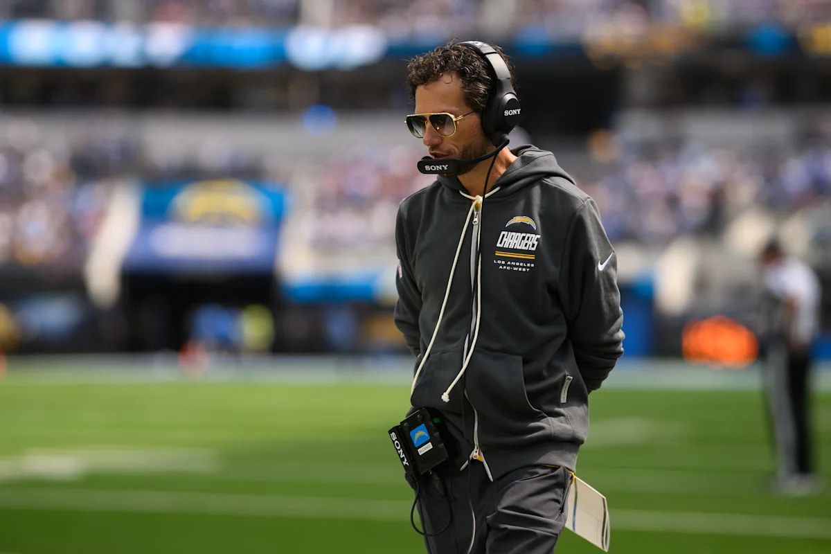 Los Angeles Chargers staff member wearing a headset and hoodie on the football sideline