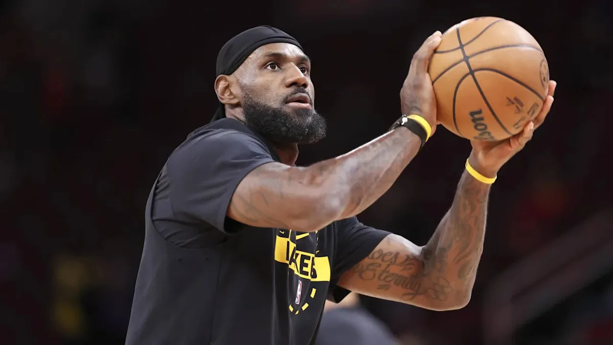 Basketball player in black Lakers shirt holds a basketball during a game