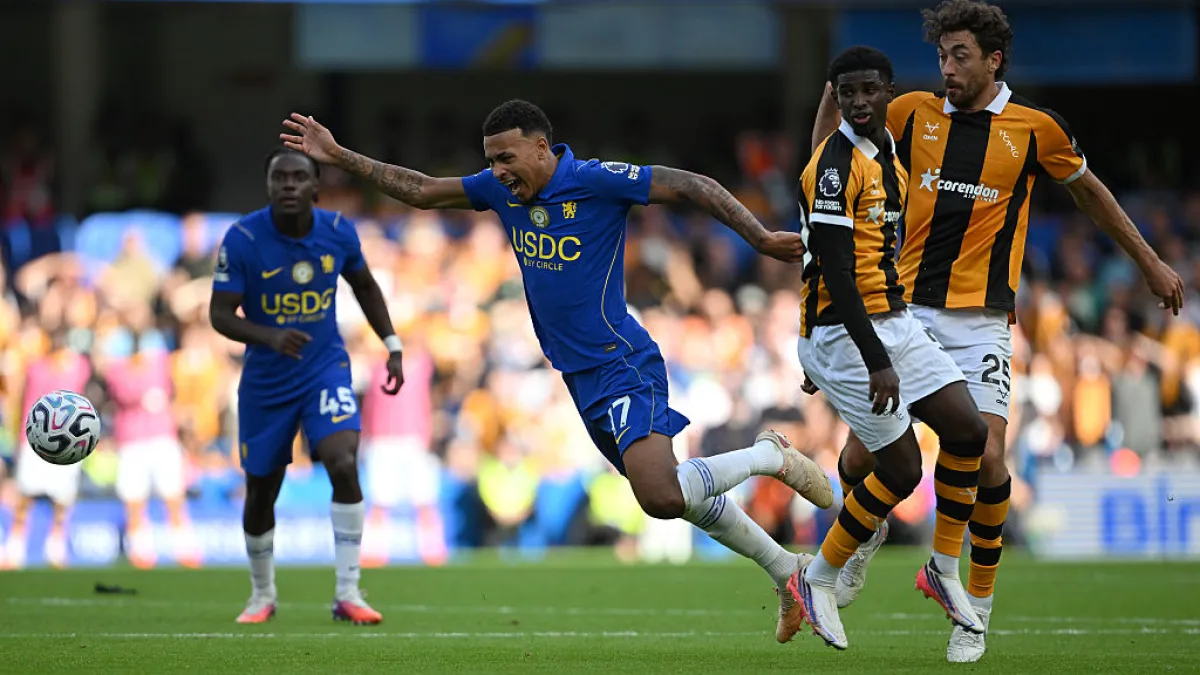 Chelsea players in blue challenge Hull City players in black and amber during a football match