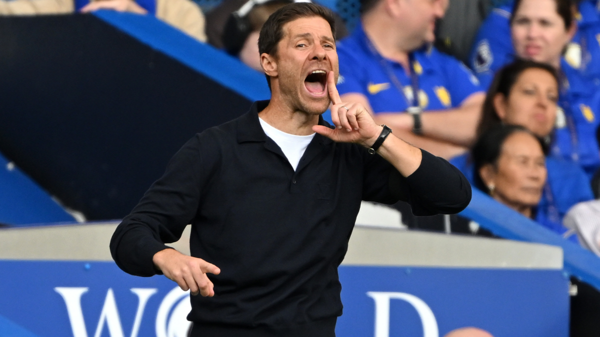 Man in black shirt shouting and gesturing from the touchline during a football match
