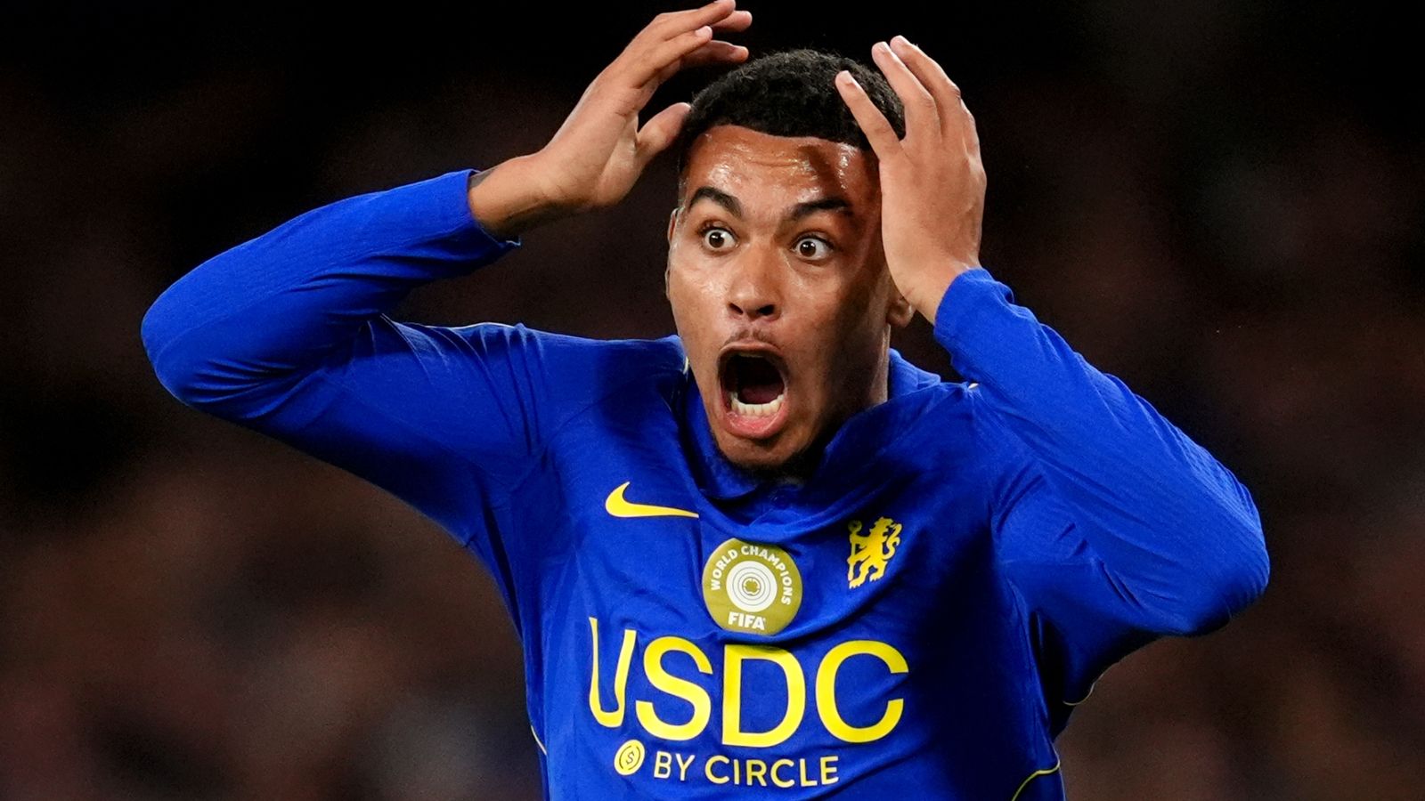 Chelsea player in blue shirt holds his head with mouth open in apparent shock