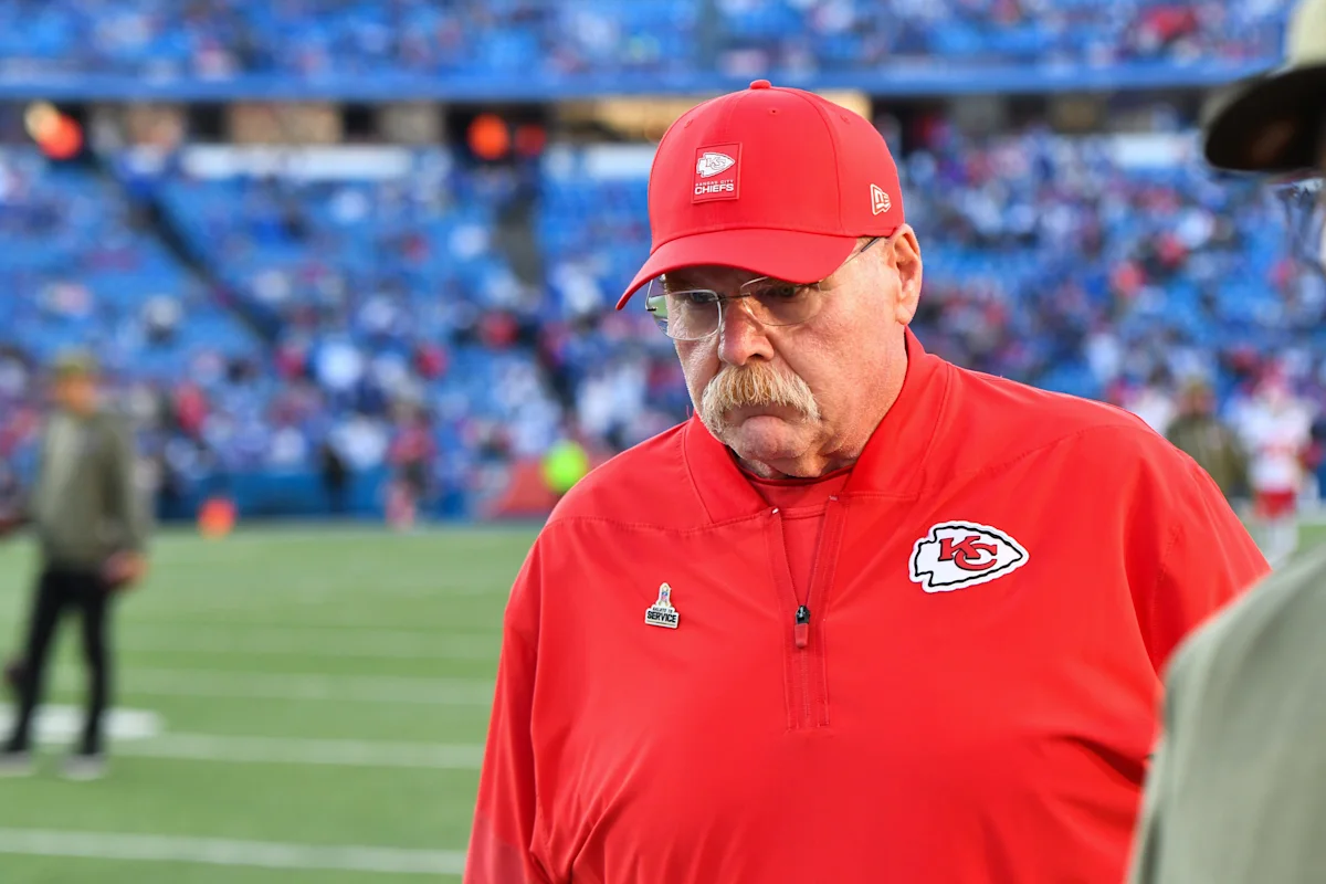 Kansas City Chiefs coach Andy Reid stands on the sideline wearing a red cap and jacket.