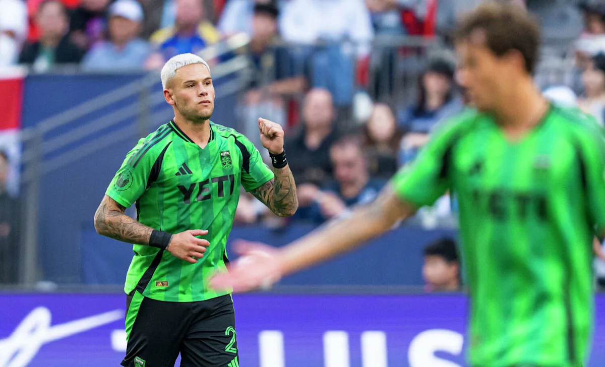 Austin FC player in green jersey raises a fist during a soccer match