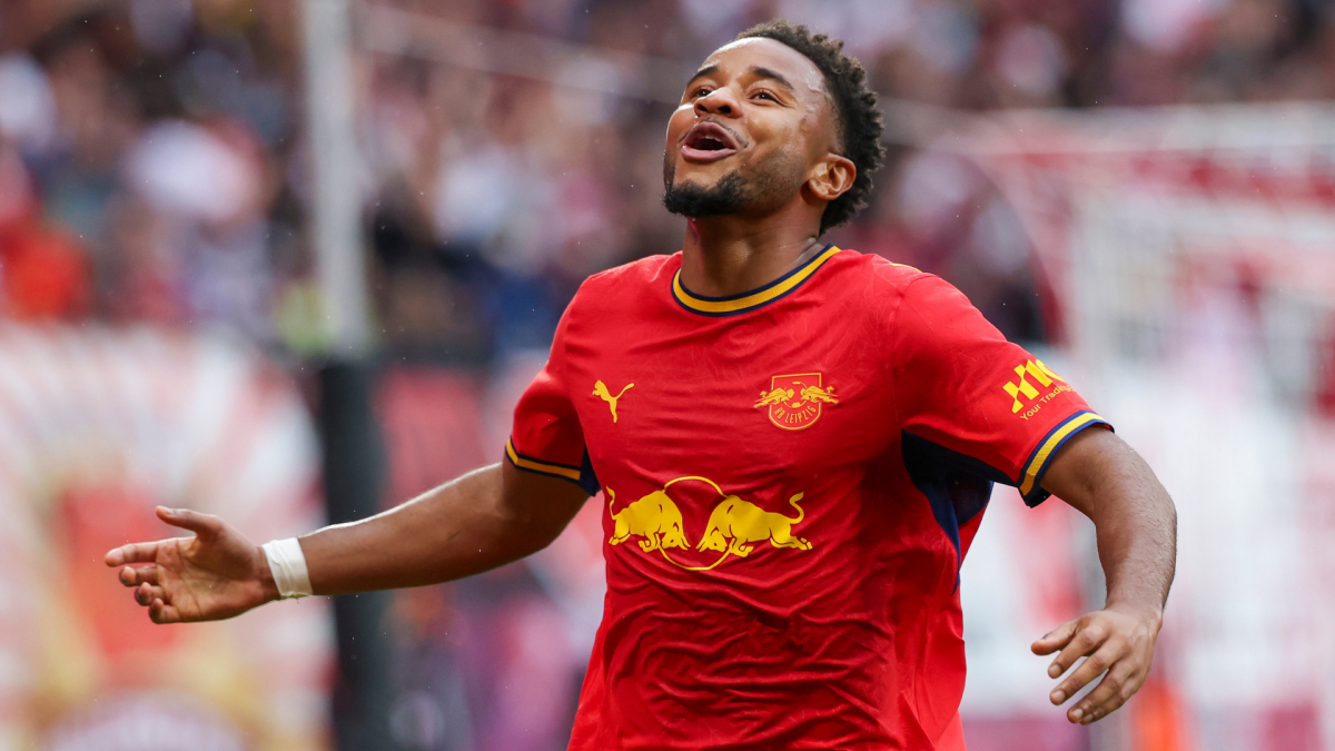 Footballer in a red RB Leipzig jersey celebrates with arms outstretched during a match