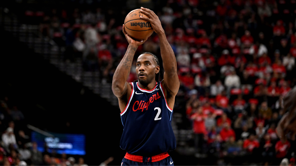 Clippers player wearing number 2 raises a basketball overhead for a shot.