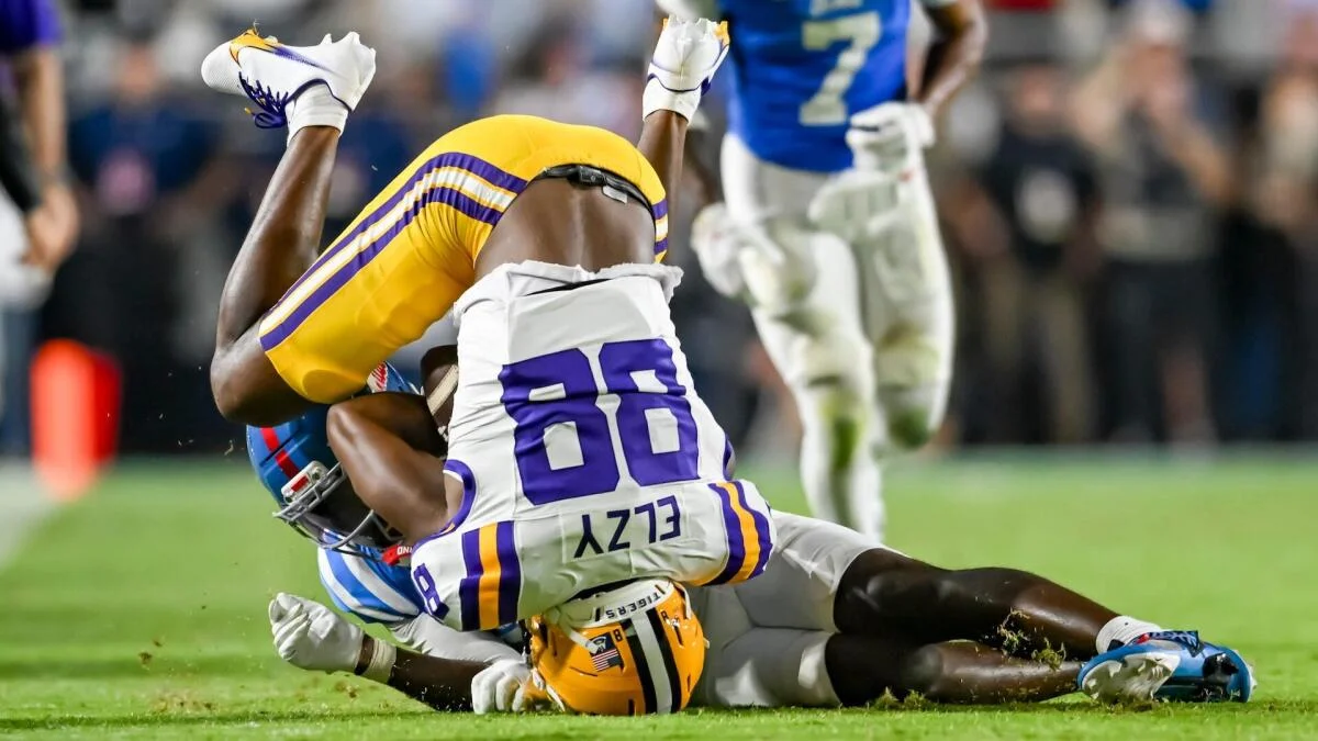 Football players collide during a tackle as one LSU player is flipped upside down.