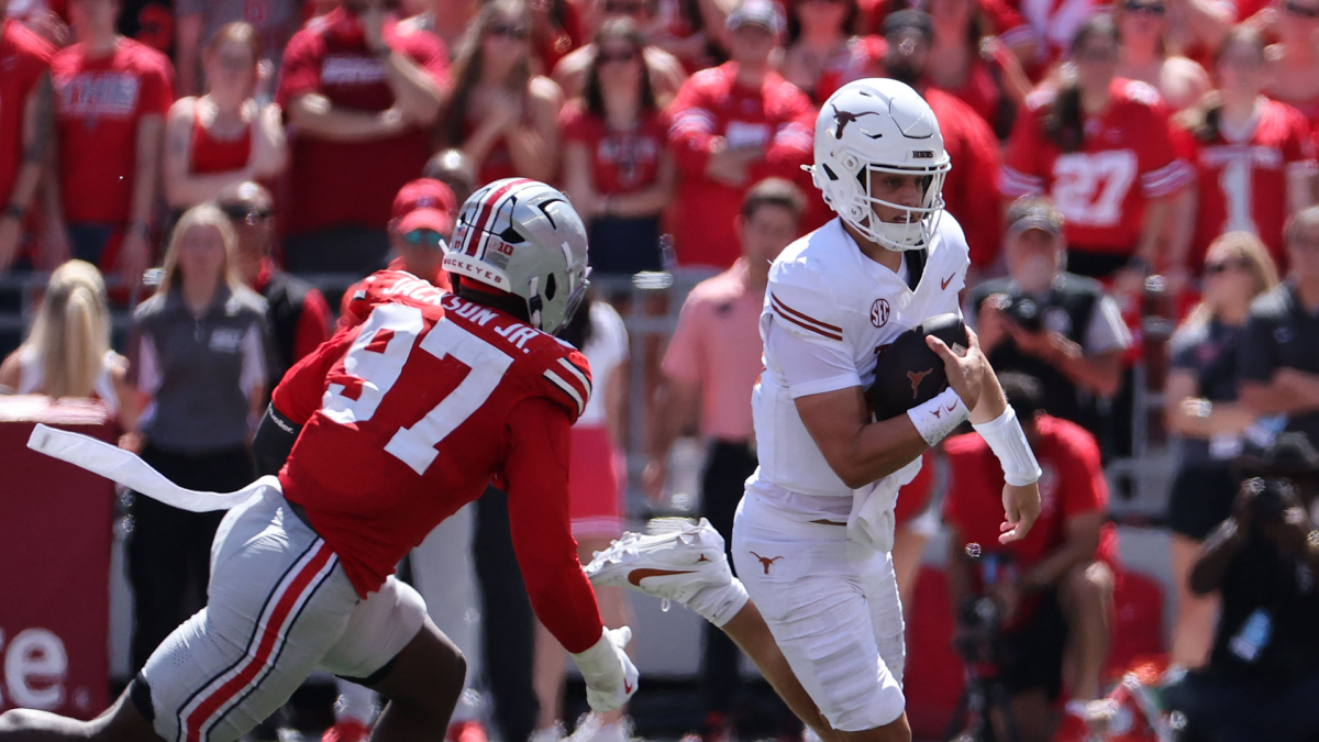 Ohio State defender pursues Texas quarterback carrying the football during a college football game