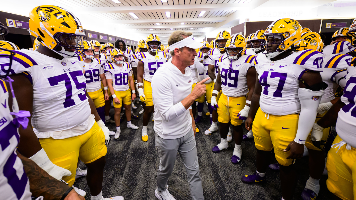 Football coach addresses LSU players in a locker room before a game