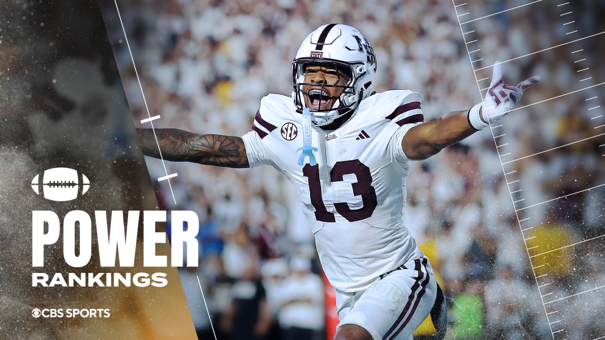 Mississippi State player in a white number 13 uniform celebrates with arms outstretched on the field.