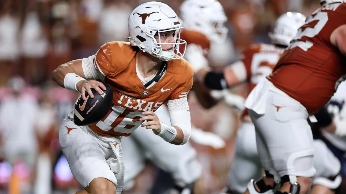 Texas quarterback in orange jersey runs with the football during a college football game